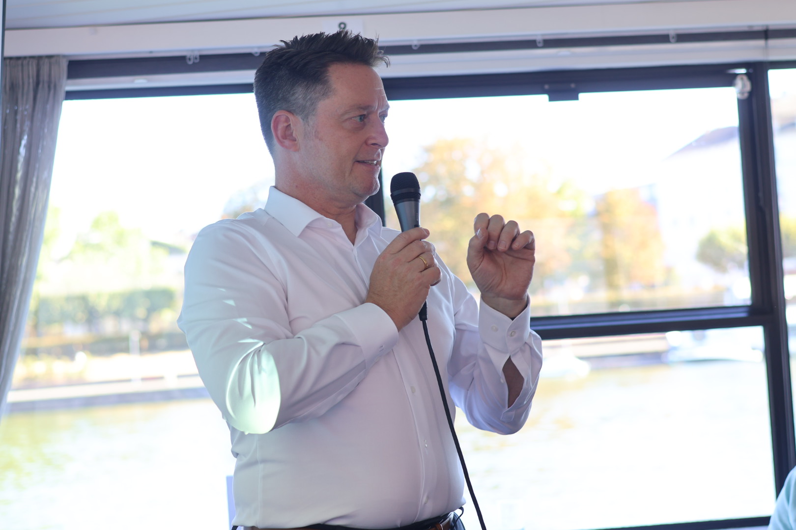 Rechtsanwalt Jan Lehniger spricht beim RA-MICRO KI-Abend auf dem Fahrgastschiff in Frankfurt in ein Mikrofon.